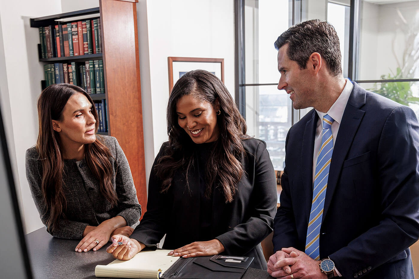 Three attorneys working together at a table.